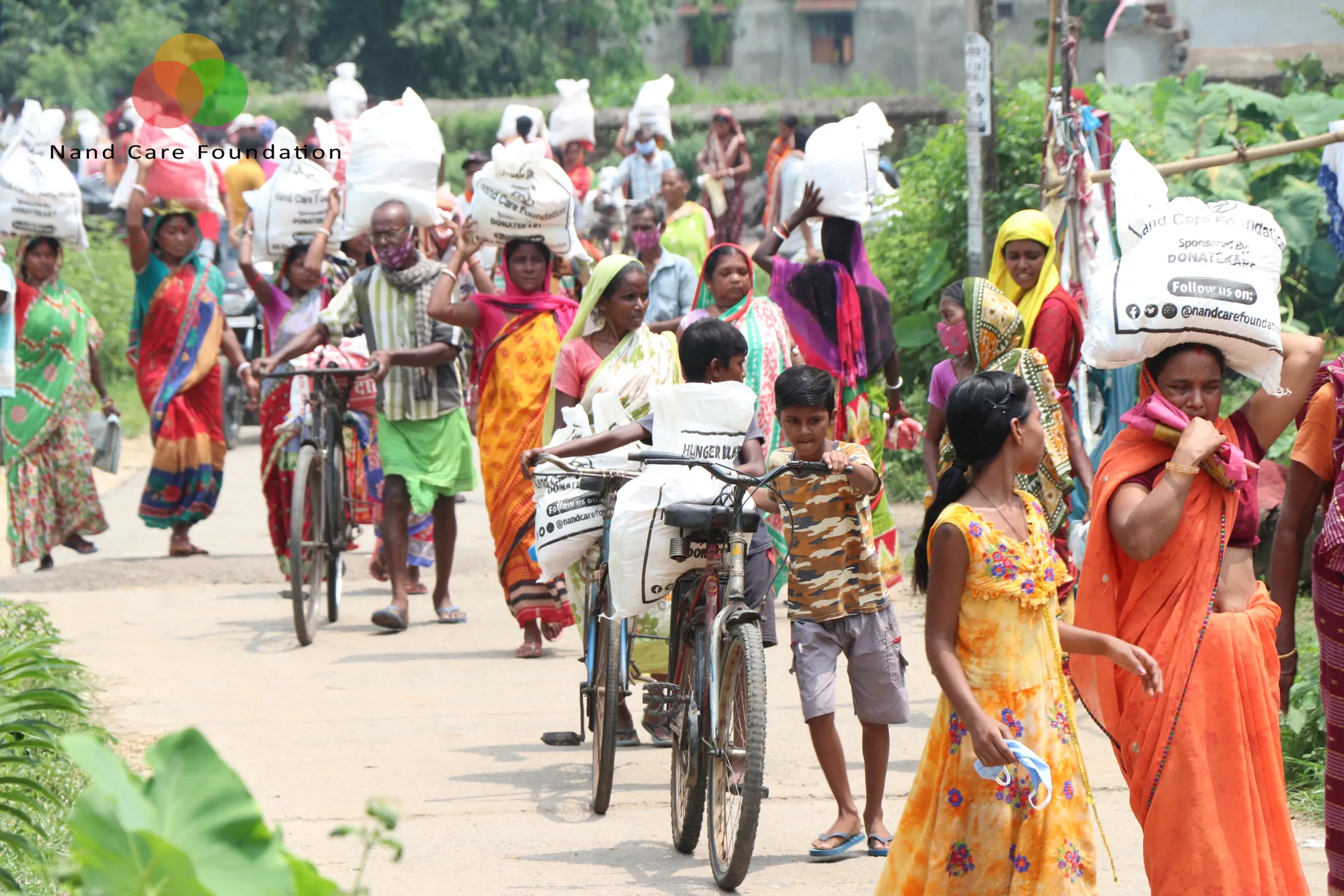 Villagers carrying ration sacks home on foot and by bicycle
