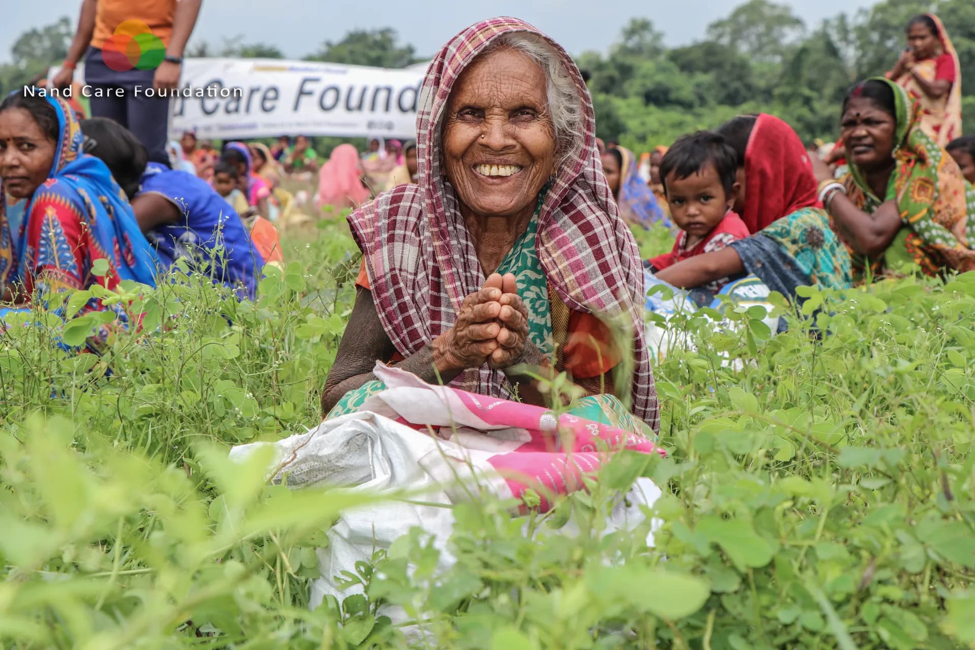 Elderly woman smiling with folded hands after receiving a ration kit