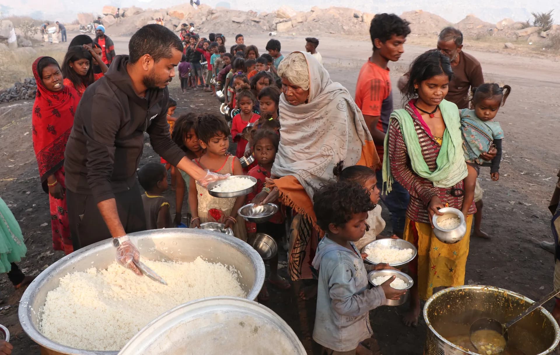 Volunteer serving rice to children and families in the coal belt